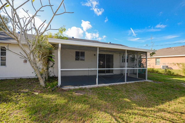 back of property with a yard and a sunroom