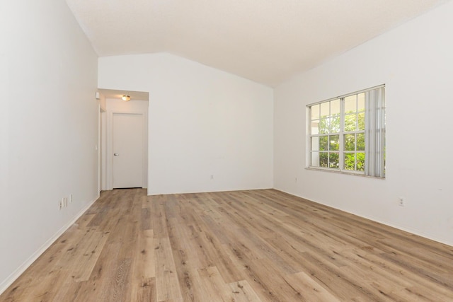 empty room with lofted ceiling and light wood-type flooring