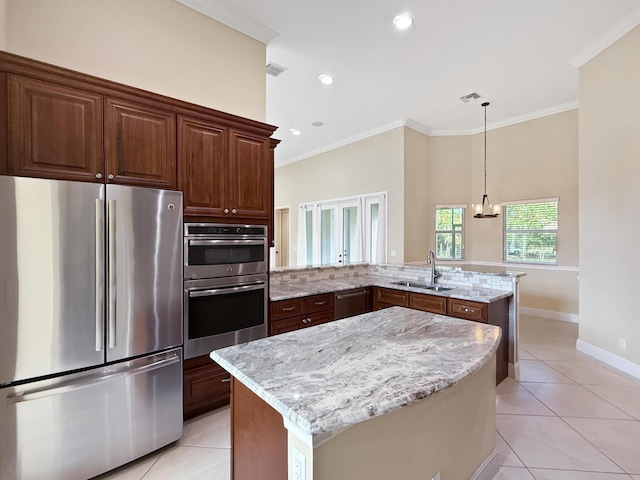 kitchen featuring appliances with stainless steel finishes, sink, a chandelier, light tile patterned floors, and kitchen peninsula