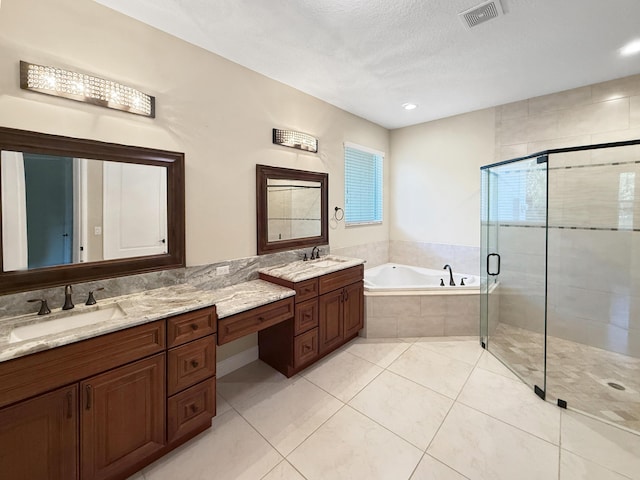 bathroom featuring vanity, shower with separate bathtub, tile patterned flooring, and a textured ceiling