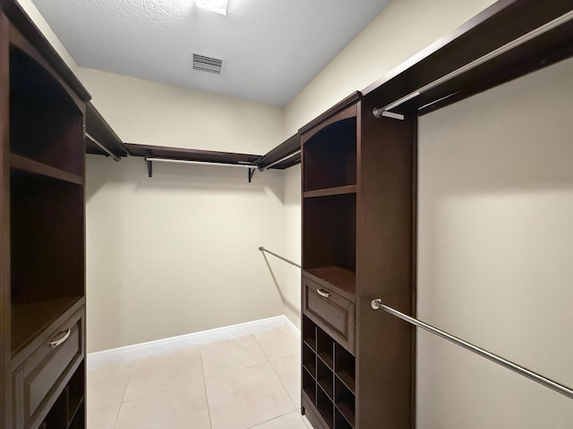 walk in closet with light tile patterned flooring