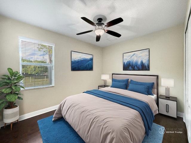 bedroom with dark hardwood / wood-style flooring and ceiling fan