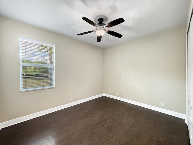 empty room with dark hardwood / wood-style floors and ceiling fan