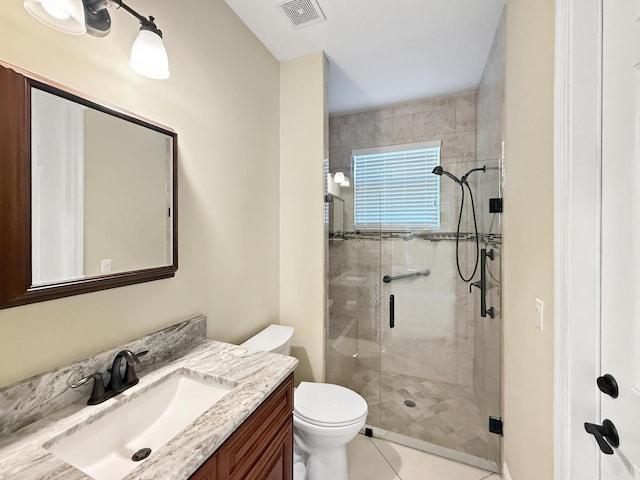 bathroom featuring vanity, tile patterned flooring, a shower with shower door, and toilet