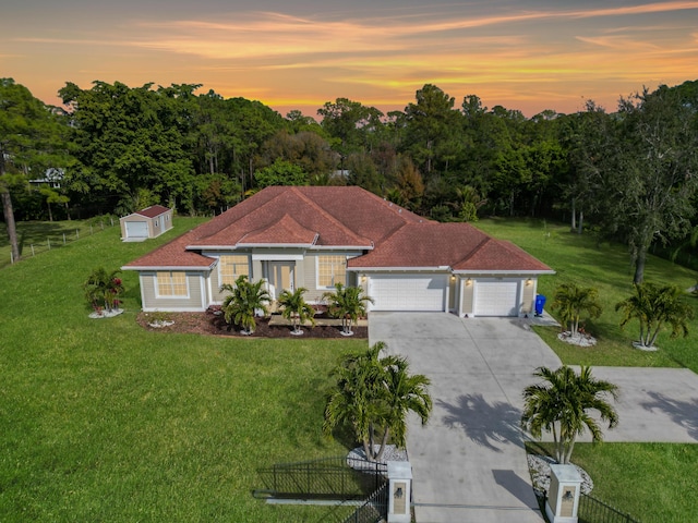 mediterranean / spanish-style home featuring a garage, a yard, concrete driveway, and fence