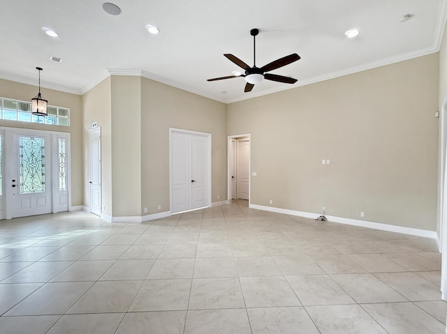 foyer with crown molding, ceiling fan, a towering ceiling, and light tile patterned floors