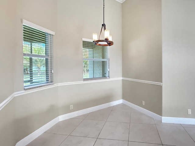 unfurnished dining area featuring a chandelier and light tile patterned flooring