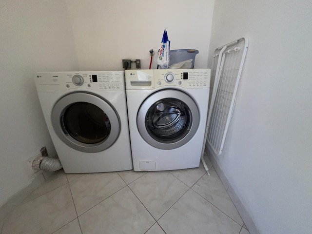 washroom featuring washing machine and dryer and light tile patterned flooring