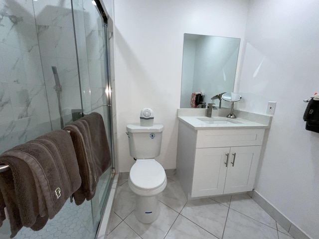 bathroom with tile patterned flooring, a shower with shower door, vanity, and toilet