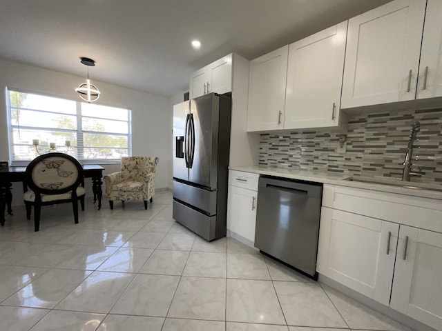 kitchen with hanging light fixtures, stainless steel refrigerator with ice dispenser, backsplash, white cabinets, and black dishwasher