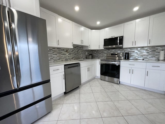 kitchen with stainless steel appliances, white cabinetry, and tasteful backsplash