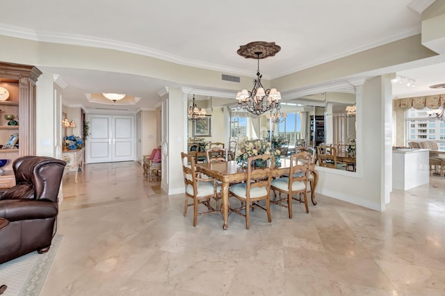 dining room with a healthy amount of sunlight, ornamental molding, and ornate columns