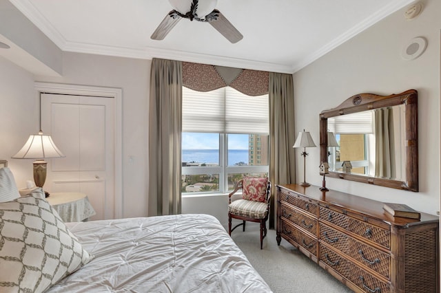 carpeted bedroom featuring ceiling fan, ornamental molding, and a water view