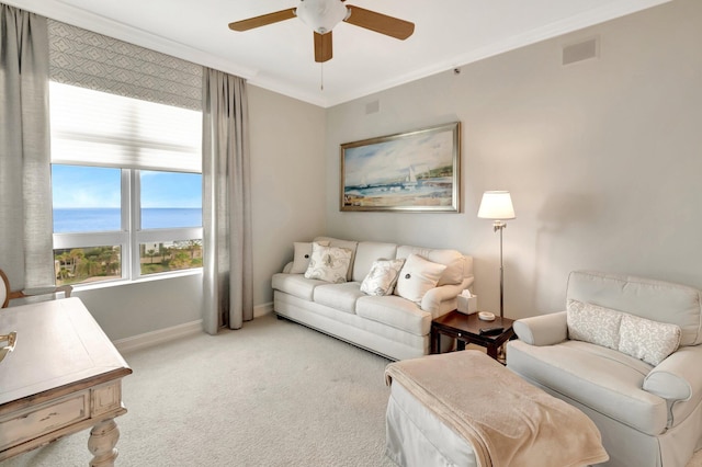 carpeted living room with a water view, ceiling fan, and crown molding