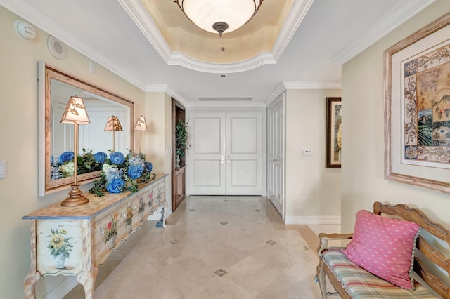 hallway with a raised ceiling and crown molding