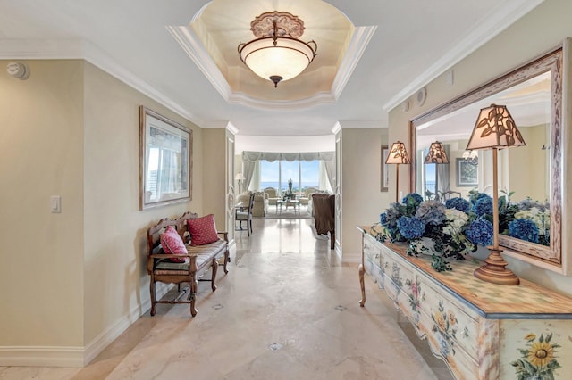 hallway featuring ornamental molding and a tray ceiling