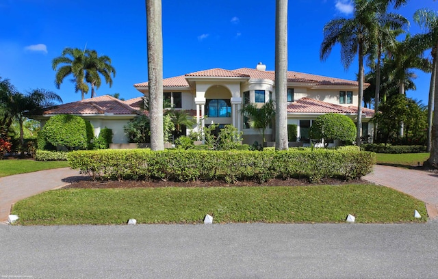 mediterranean / spanish-style home with a front lawn