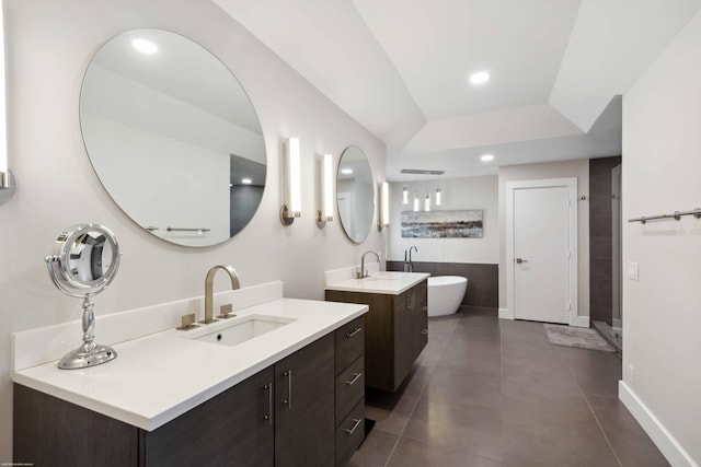 bathroom with a bathtub, vanity, and vaulted ceiling