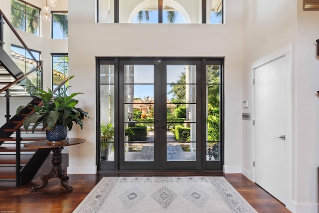 foyer entrance featuring a high ceiling, dark wood-type flooring, and french doors