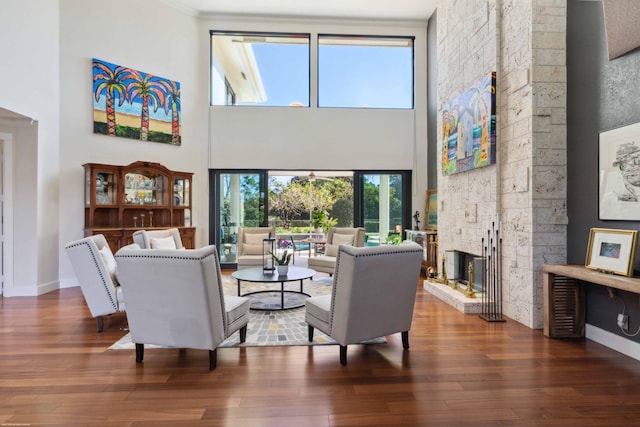 living room featuring a high ceiling, a fireplace, and dark hardwood / wood-style floors