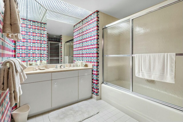 bathroom featuring tile patterned flooring, enclosed tub / shower combo, and vanity