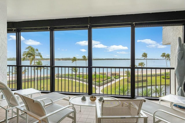 sunroom / solarium featuring a water view