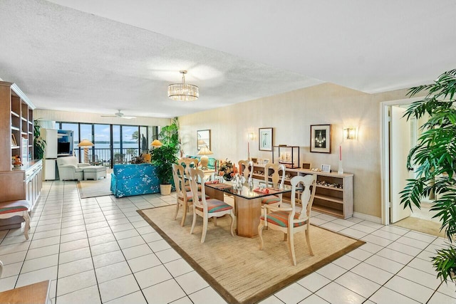 dining area featuring ceiling fan with notable chandelier, a textured ceiling, and light tile patterned floors