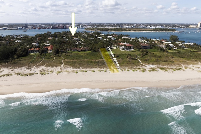 birds eye view of property with a water view and a beach view