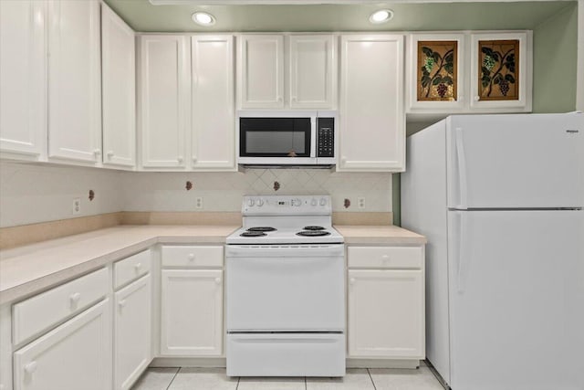 kitchen featuring backsplash, white appliances, white cabinetry, and light tile patterned floors