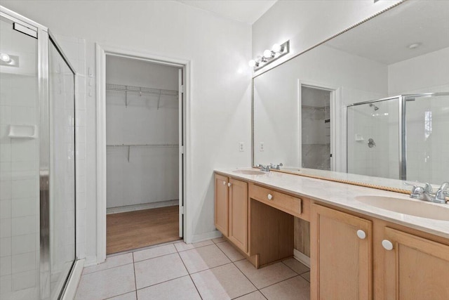 bathroom featuring tile patterned flooring, an enclosed shower, and vanity