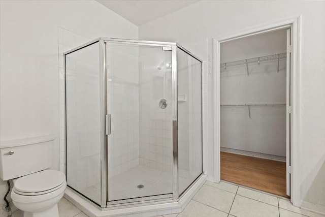 bathroom featuring toilet, tile patterned flooring, and walk in shower