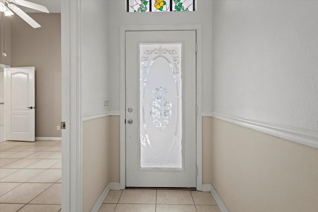 foyer entrance with ceiling fan, a wealth of natural light, and light tile patterned floors