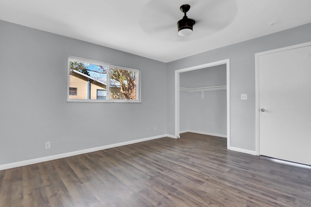 unfurnished bedroom featuring ceiling fan, dark hardwood / wood-style flooring, and a closet