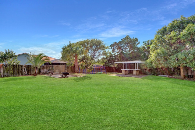 view of yard with an outdoor fire pit and a playground