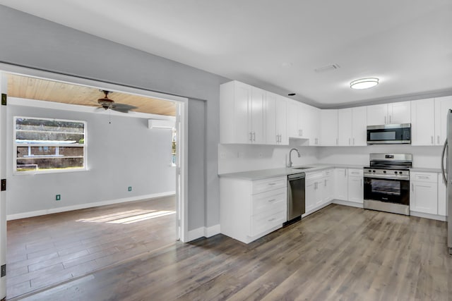 kitchen with stainless steel appliances, white cabinetry, ceiling fan, and light hardwood / wood-style floors