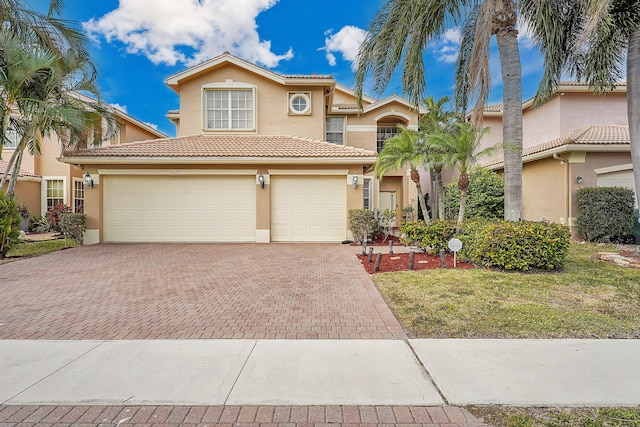 mediterranean / spanish house with a front lawn and a garage