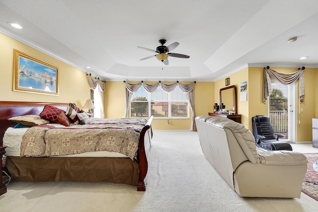 carpeted bedroom with ceiling fan, a raised ceiling, access to outside, and ornamental molding