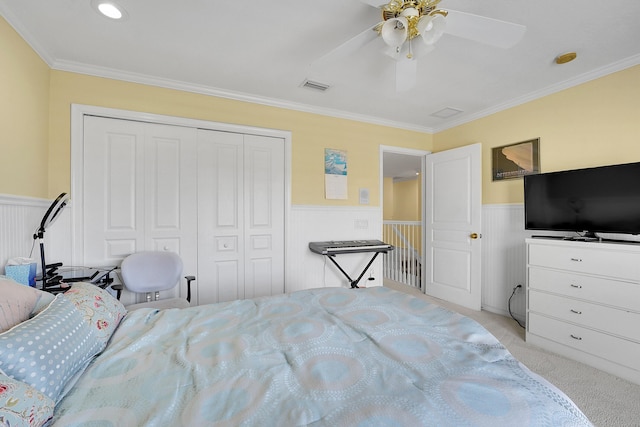 bedroom with light carpet, ceiling fan, ornamental molding, and a closet