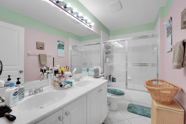 full bathroom with tile patterned floors, vanity, toilet, and combined bath / shower with glass door