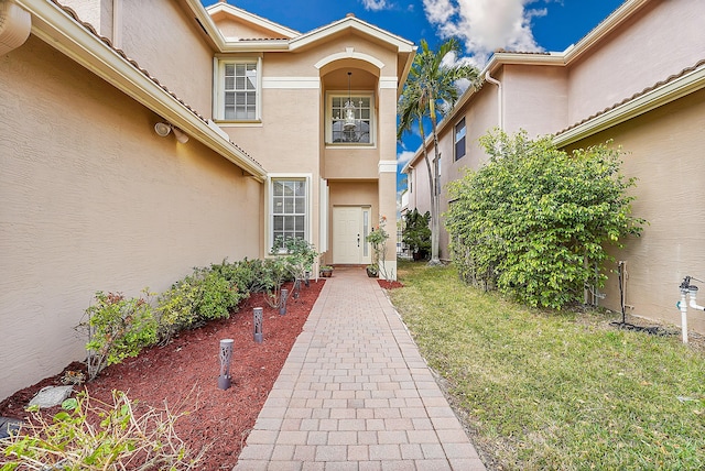 view of exterior entry with a yard