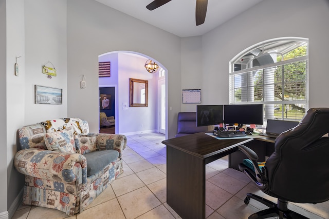 tiled office featuring ceiling fan with notable chandelier