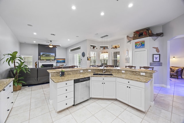 kitchen with an island with sink, dishwasher, sink, and white cabinetry