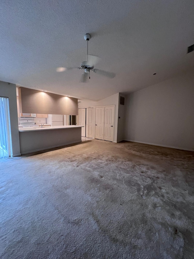 unfurnished living room featuring ceiling fan, carpet, and a textured ceiling