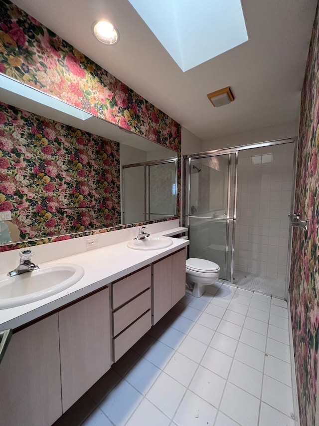 bathroom featuring toilet, a skylight, tile patterned floors, an enclosed shower, and vanity