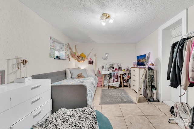 bedroom featuring a textured ceiling and light tile patterned flooring