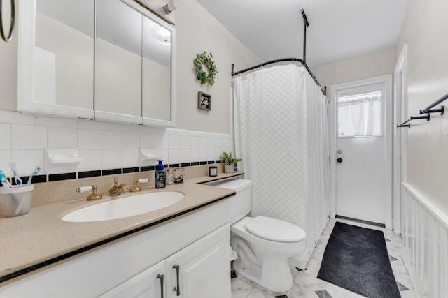 bathroom featuring toilet, decorative backsplash, and vanity