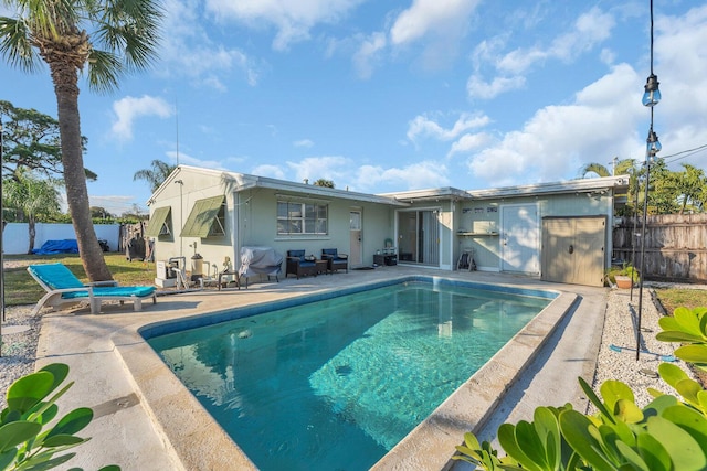 rear view of property with a fenced in pool and a patio