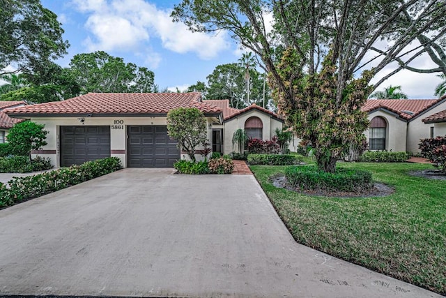 mediterranean / spanish house with a front lawn and a garage