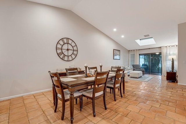 tiled dining space featuring lofted ceiling with skylight