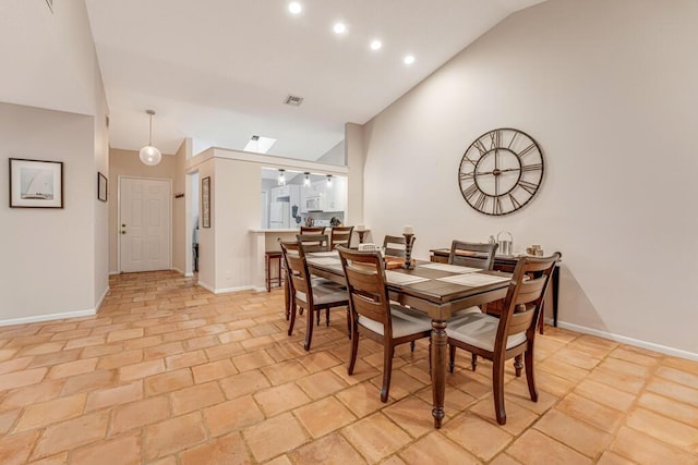 dining space featuring high vaulted ceiling and a skylight